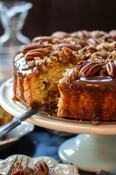 a bundt cake with pecans and caramel toppings on a serving platter