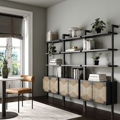 a living room with bookshelves and a table in front of a large window