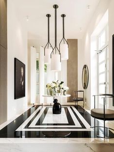 a living room with black and white stripes on the floor, chandeliers hanging from the ceiling