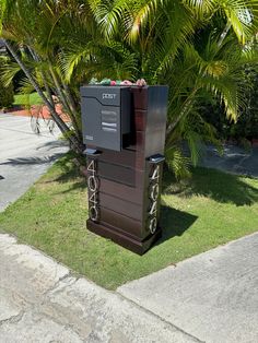 a mailbox sitting in the grass next to a tree