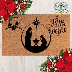 a door mat with a nativity scene in the center and poinsettis around it