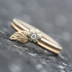 Dainty Diamond Leaf is a cute little flower and leaf bridal wedding ring set. This delicate design in 14k white and yellow gold is perfect for a fall ceremony! One white brilliant 1.5mm diamond (VS quality, G color) sits in the center of this lovely flower. A two tone set that creates a nice visual contrast yet remains subtle and petite. Shown in size 6.75 (can be sized) *Please inquire about additional cost for sizes above 9 nangijalajewelry.etsy.com *For your own protection and in order to com Flower-shaped Yellow Gold Wedding Ring For Anniversary, Wedding Flower Ring With Single Diamond, Yellow Gold Flower Wedding Ring For Anniversary, Yellow Gold Flower Ring For Wedding, Delicate White Gold Flower Ring For Wedding, Delicate Gold Flower Ring For Wedding, Yellow Gold Wedding Flower Ring, Delicate Flower Ring With Rose Cut Diamonds For Wedding, Gold Wedding Flower Ring With Single Diamond