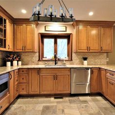 a large kitchen with wooden cabinets and marble counter tops on the floor, along with stainless steel appliances