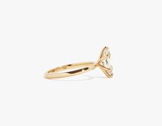 a yellow gold ring with a single stone in the center and an arrow shaped band