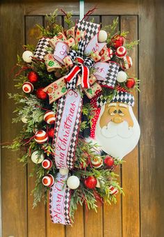 a christmas wreath hanging on the front door with santa claus and other ornaments around it