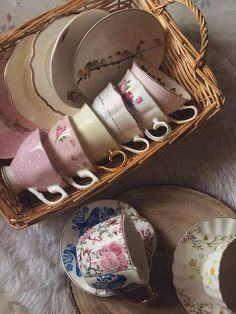 a basket filled with lots of cups and saucers