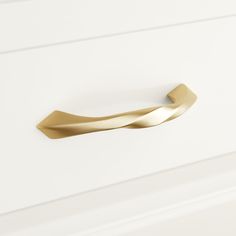 a close up of a door handle on a white cabinet