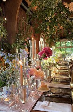 a long table with flowers and candles is set up for a formal dinner or party