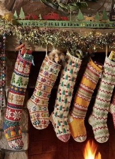 christmas stockings hanging from a mantel in front of a fireplace