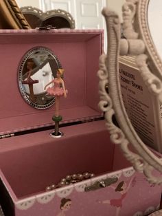 a pink box with a ballerina figure in the middle and a mirror behind it