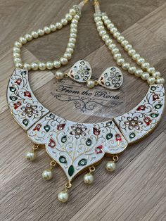 One of a kind white enamel/Meenakari work necklace set. It's a detailed set with hand painted Meena work throughout the neckpiece and CZ stones are put on it. The gorgeous heart shape makes it look all the different. Comes with gorgeous matching earrings with ivory pearls. Work Necklaces, Bridal Necklace Set, Necklace Collar, Pearl Bangle, Ivory Pearl, Ruby Stone, Gold Plated Rings, American Diamond, Bridal Necklace