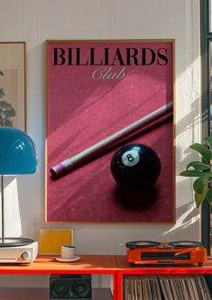 a billiards poster hangs on the wall next to a lamp and record player