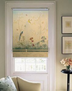 a living room filled with furniture and flowers on the window sill next to a chair