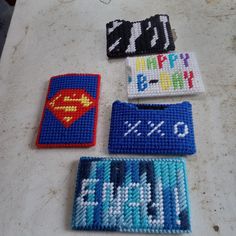 four cross stitch coasters on a table with the words happy birthday written in white and blue