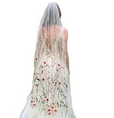 the back of a woman wearing a white veil with flowers on it and pink trim