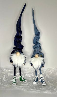 two gnomes dressed in blue jeans and white hair are standing next to each other