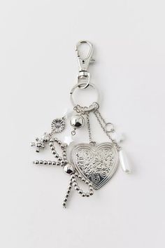 a heart shaped keychain with charms attached to it's sides on a white surface