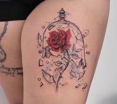 a woman's thigh with a rose in a glass ball tattoo on it,