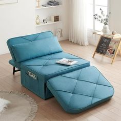 a blue chaise lounger sitting on top of a hard wood floor next to a window