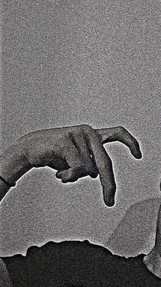 a black and white photo of two hands reaching out to touch each other's fingers