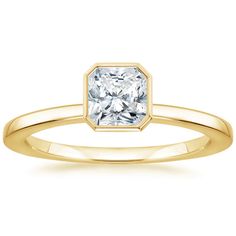 a yellow gold engagement ring with a square cut diamond in the center, on a white background