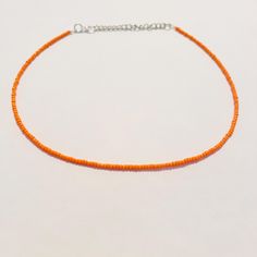 This beautiful necklace is handmade with dainty orange seed beads. It comes in a variety of lengths (14, 16, 18, 20, 22, or 24 inches) ranging from a choker fit to a longer necklace. Each necklace also comes with additional extender chain, making the necklace easily adjustable! The orange color is perfect for fall and Halloween and goes well with so many different outfits! Orange Beaded Choker Jewelry, Adjustable Orange Beaded Necklaces With Tiny Beads, Adjustable Orange Beaded Necklace With Tiny Beads, Adjustable Orange Single Strand Beaded Necklace, Orange Choker With Colorful Beads, Adjustable Orange Choker With Round Beads, Orange Tiny Beads Choker Necklace, Orange Necklaces With Tiny Beads For Gift, Orange Beaded Choker With Tiny Beads