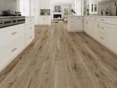 a large kitchen with white cabinets and wood flooring