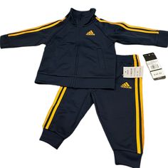 Adidas 2 Piece Jog Suit Navy Blue With Gold Trim Casual Navy Sets For Spring, Navy Cotton Sets For Spring, Sporty Blue Cotton Sets, Blue Cotton Sporty Sets, Fitted Blue Playtime Sets, Fitted Blue Sports Sets, Fitted Navy Sets For Spring, Casual Blue Playwear Sets, Adidas Long Sleeve Playwear Sets