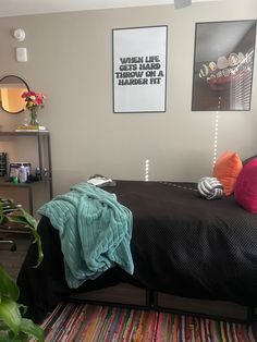 a bedroom with a bed, plants and pictures on the wall