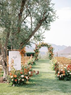 an outdoor ceremony setup with flowers and greenery