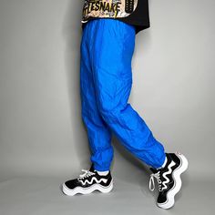 "Vintage Track Pants Royal Blue Nylon Joggers Elastic Cuffs has Ankle Zippers Lined Head 90s Skate / Streetwear Great Condition: 9/10 Men's Size: Medium My Hands in Pockets = It has Pockets No Hands in Pockets = Does Not Have Pockets Drawstring Will be Visible in Forward Pic, if not Visible it Does Not Have a Drawstring About me: I am 6' 0\" for reference I generally wear a Large (32\" inseam) I Model XS to 2XL sweatpants, I find that you can often size up or down with 95% of sweatpants and they fit the same" 90s Style Baggy Blue Pants, 90s Style Blue Baggy Pants, Sporty Blue Pants With Elastic Cuffs, Blue Hip Hop Pants For Spring, Retro Blue Bottoms For Streetwear, Blue Stretch Pants For Streetwear, Trendy Baggy Blue Parachute Pants, Trendy Blue Baggy Parachute Pants, Blue Baggy Parachute Pants For Streetwear