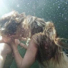 two women are kissing under the water