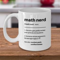 a white coffee mug with the definition of math nerd on it sitting on a wooden table