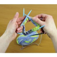 two hands are holding yarn and knitting needles