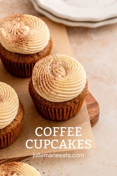 three cupcakes sitting on top of a cutting board with frosting in them