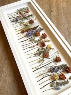 a white tray with dried flowers on it