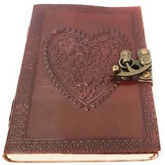 an old book with a pair of scissors on it's cover and a heart - shaped design