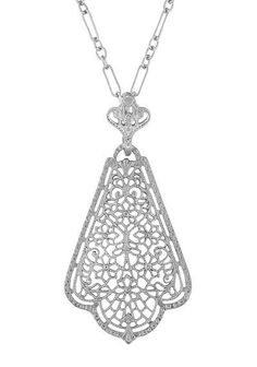 This original vintage Edwardian filigree pendant necklace design is hand crafted in solid 925 sterling silver and finished with a bright high polish anti-tarnish rhodium finish, making it a perfect coordinating match for white gold and platinum items in your jewelry collection. The scalloped body of the pendant features a detailed floral vintage filigree design, dangling from a fleur-de-lis inspired scalloped bail for attractive eye-catching movement. The finished open gallery around the side of Silver Filigree Fine Jewelry Necklace, Antique White Gold Filigree Necklace, Silver Filigree Pendant Jewelry, Vintage Filigree Pendant Necklace, Antique Silver Filigree Pendant Necklace, Filigree Pendant Necklace, Antique Silver Jewelry, Filigree Necklaces, Edwardian Jewelry