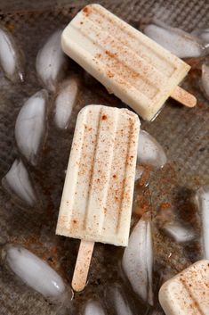 two popsicles sitting on top of ice in a frying pan with brown sugar