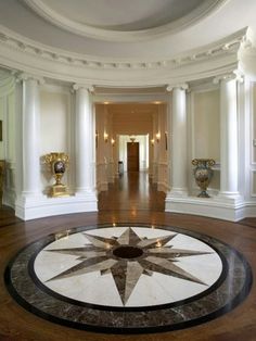 a large circular room with columns and a star on the floor