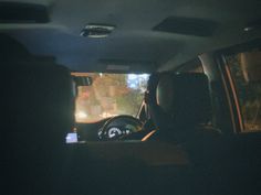 the interior of a car at night with lights on and people sitting in the passenger seat