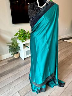 So soft, rich, flowy and elegantly glittery! Step into your saree elegance with this superbly made party wear saree. The saree fabric is a soft satin georgette and is bordered by a velvet border adorned with studded stone work. Pallu is running and saree shade is a green and border is black velvet with sequin/stone studs. The saree comes with a sequin worked, back open and padded blouse as shown in the picture. A running blouse is also attached to the saree. Falls/pico can be done for an extra price Size of stitched blouse is 38-42 inches. Its stitched to 38 inches and has lot of room inside to alter to 42 inches. 38-42 inches stitched blouse | party wear, satin georgette saree with velvet border | stone work sarees online shopping usa | Diwali | ethnic sarees | satin saree | green saree | Blouse Party Wear, Indian Sari Dress, Sari Dress, Padded Blouse, Ethnic Sarees, Satin Saree, Green Saree, Indian Sari, Wear Saree