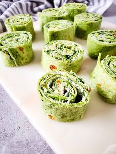 several rolled up sandwiches on a cutting board