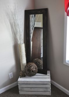 a mirror sitting on top of a shelf next to a vase