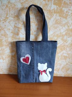 a denim bag with patches and hearts on it