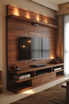 a living room with a flat screen tv mounted to the side of a wooden entertainment center