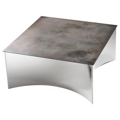 a metal table with a curved design on the top and silver finish to it's surface