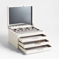 an open jewelry box with three drawers and two wedding rings on the bottom one drawer