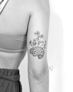 a black and white photo of a woman's arm with flowers on it