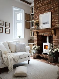 a living room filled with furniture and a fire place next to a brick wall in front of a window